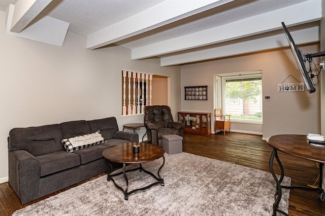 living room featuring dark wood-type flooring, beam ceiling, and baseboards