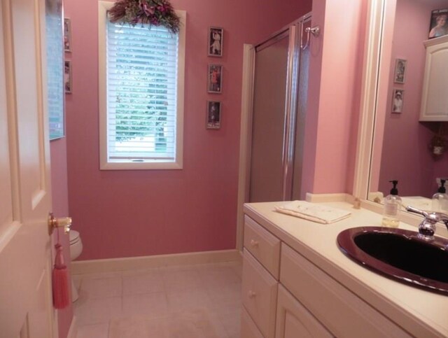 322 S Temple St, Osceola, IA 50213 - full bathroom with a stall shower, vanity, toilet, baseboards, and tile patterned floors