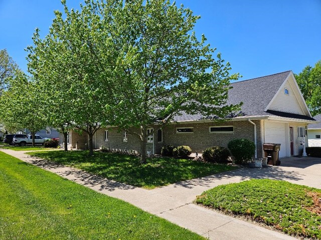 322 S Temple St, Osceola, IA 50213 - view of front of property with a garage, brick siding, a front lawn, driveway, and a shingled roof