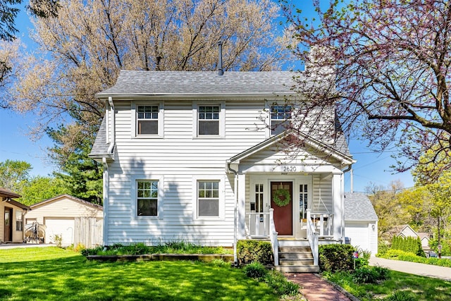 2620 35th St, Des Moines, IA 50310 - view of front of home with a front lawn, an outdoor structure, a garage, a shingled roof, and driveway