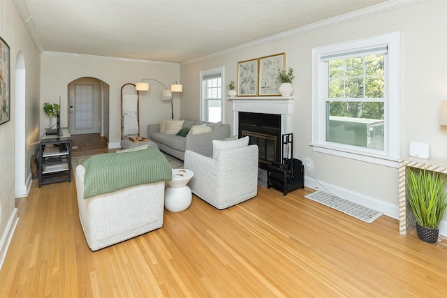 2620 35th St, Des Moines, IA 50310 - living area with arched walkways, wood finished floors, plenty of natural light, a glass covered fireplace, and crown molding