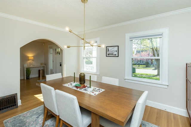 2620 35th St, Des Moines, IA 50310 - dining space with arched walkways, ornamental molding, wood finished floors, a chandelier, and a textured ceiling