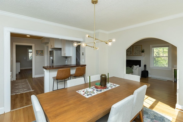 2620 35th St, Des Moines, IA 50310 - dining room with arched walkways, wood finished floors, a textured ceiling, healthy amount of natural light, and ornamental molding