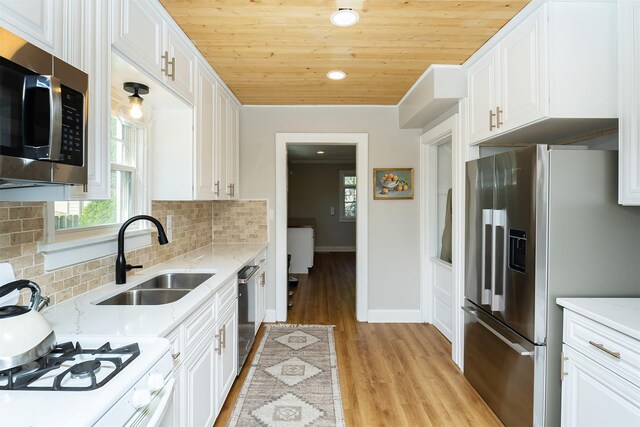 2620 35th St, Des Moines, IA 50310 - kitchen with stainless steel appliances, a sink, light wood-type flooring, wood ceiling, and white cabinets