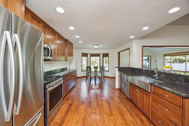 15919 Hawthorn Cir, Clive, IA 50325 - kitchen with stainless steel appliances, a sink, plenty of natural light, hardwood / wood-style flooring, and a textured ceiling