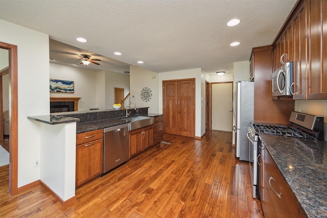 15919 Hawthorn Cir, Clive, IA 50325 - kitchen featuring appliances with stainless steel finishes, a sink, wood-type flooring, a textured ceiling, and recessed lighting