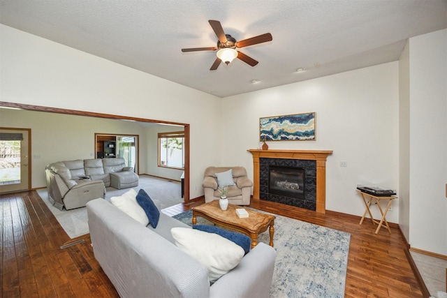 15919 Hawthorn Cir, Clive, IA 50325 - living area featuring a ceiling fan, wood finished floors, a tiled fireplace, and baseboards