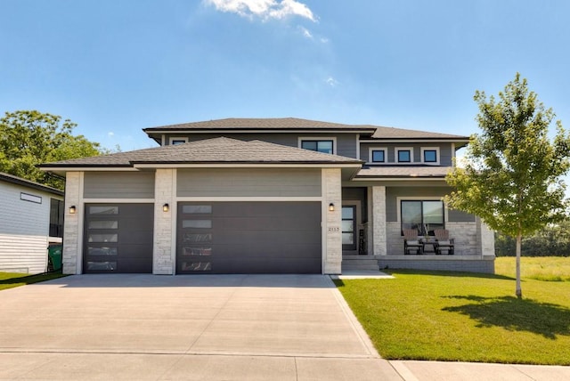 2113 NE Heritage Dr, Grimes, IA 50111 - prairie-style house featuring a garage, concrete driveway, a front lawn, a porch, and stone siding
