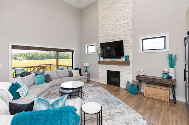 2113 NE Heritage Dr, Grimes, IA 50111 - living area with a towering ceiling, wood finished floors, and a stone fireplace