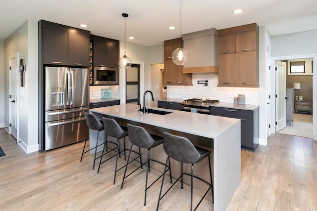 2113 NE Heritage Dr, Grimes, IA 50111 - kitchen with appliances with stainless steel finishes, a breakfast bar area, light wood-type flooring, backsplash, and light countertops