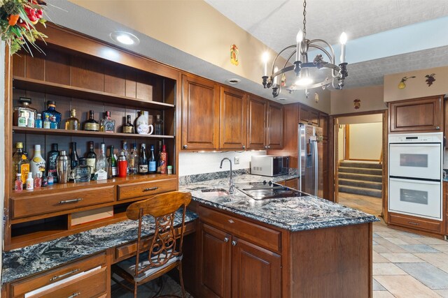 1608 W Lincoln Way, Marshalltown, IA 50158 - kitchen featuring stainless steel appliances, a sink, a chandelier, dark stone counters, and a peninsula