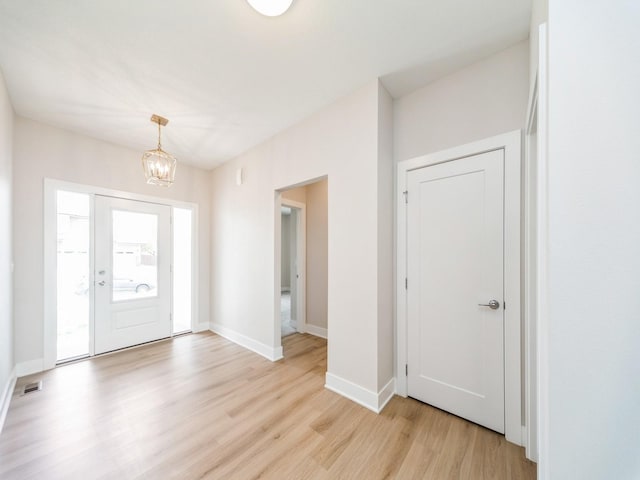 460 NW Gracewood Dr, Waukee, IA 50263 - entryway with light wood-type flooring, a chandelier, and baseboards