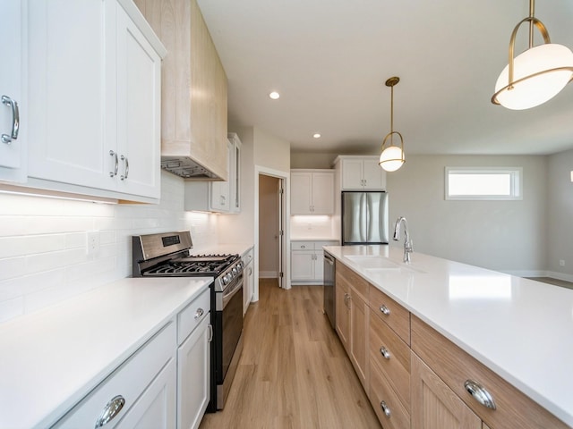 460 NW Gracewood Dr, Waukee, IA 50263 - kitchen featuring appliances with stainless steel finishes, a sink, light wood-style flooring, light countertops, and tasteful backsplash
