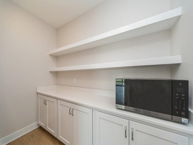 460 NW Gracewood Dr, Waukee, IA 50263 - bar with stainless steel microwave, light wood finished floors, and baseboards