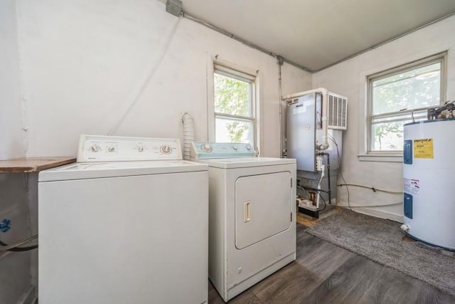 clothes washing area featuring electric water heater, washer and dryer, and dark wood finished floors