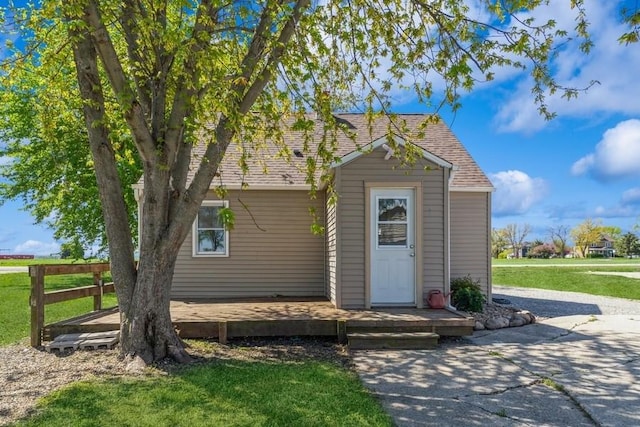 view of front of house featuring a front yard and an outdoor structure