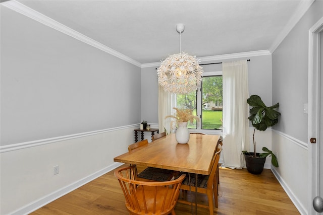 7422 Plum Dr, Urbandale, IA 50322 - dining space with a chandelier, light wood-style floors, ornamental molding, and baseboards
