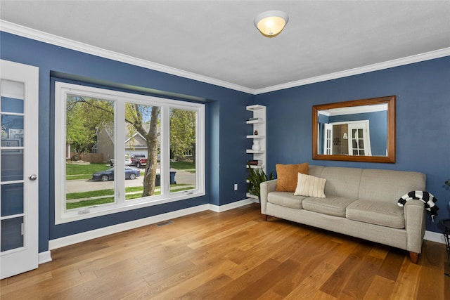 7422 Plum Dr, Urbandale, IA 50322 - living area featuring baseboards, crown molding, and wood finished floors