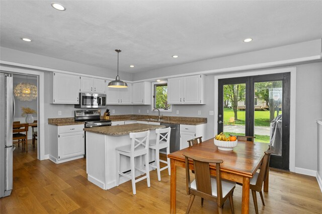 7422 Plum Dr, Urbandale, IA 50322 - kitchen with appliances with stainless steel finishes, a sink, light wood-type flooring, white cabinets, and recessed lighting