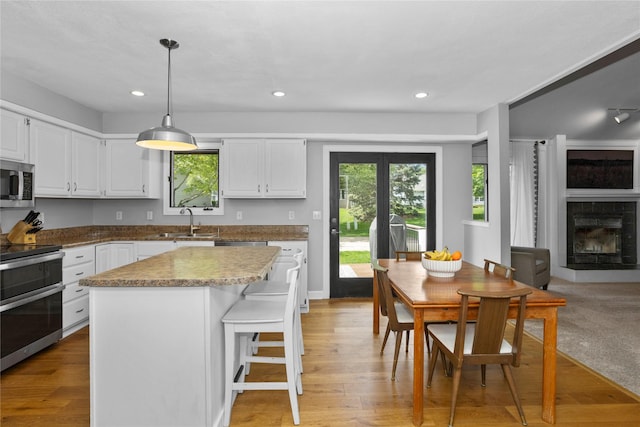 7422 Plum Dr, Urbandale, IA 50322 - kitchen with appliances with stainless steel finishes, a sink, white cabinetry, plenty of natural light, and recessed lighting