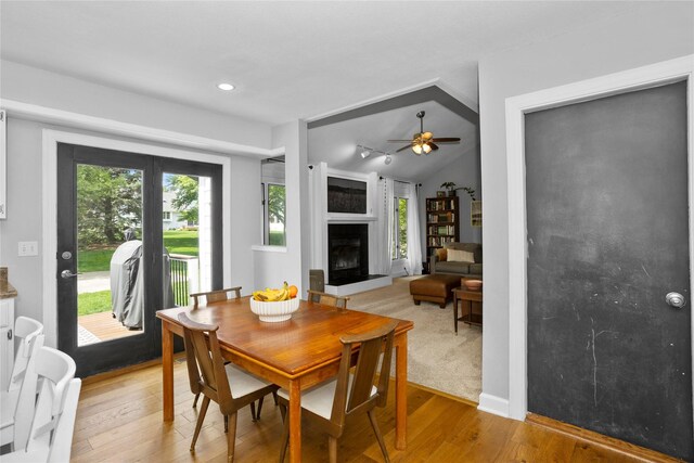 7422 Plum Dr, Urbandale, IA 50322 - dining area featuring a ceiling fan, light wood-style floors, a large fireplace, recessed lighting, and vaulted ceiling