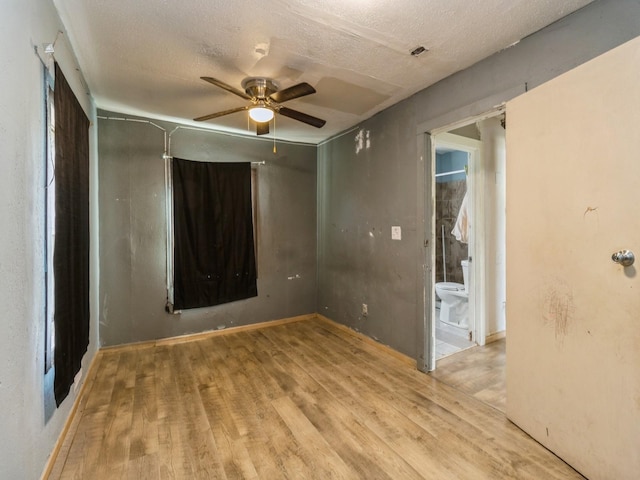 spare room with ceiling fan, wood finished floors, and a textured ceiling
