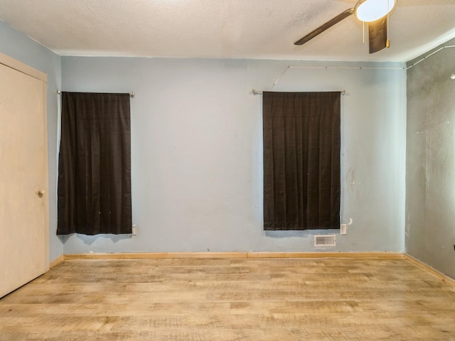 spare room with wood finished floors and ceiling fan