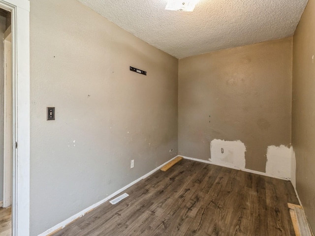 unfurnished room featuring wood finished floors, a textured ceiling, and baseboards