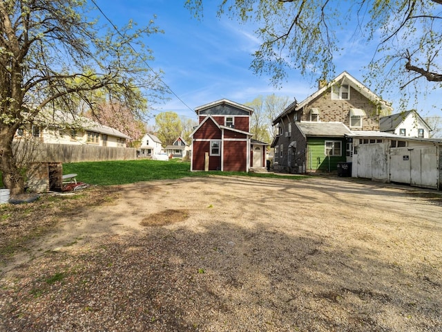 view of yard with fence, an outbuilding, and a residential view