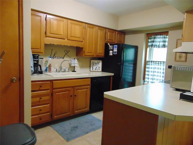 7120 Hickory Ln, Urbandale, IA 50322 - kitchen with a sink, black appliances, light countertops, brown cabinetry, and under cabinet range hood