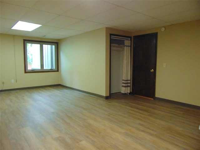 7120 Hickory Ln, Urbandale, IA 50322 - empty room featuring a drop ceiling, light wood finished floors, and baseboards