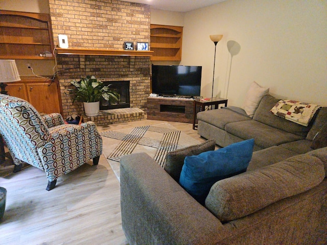 7120 Hickory Ln, Urbandale, IA 50322 - living room featuring wood finished floors and a brick fireplace