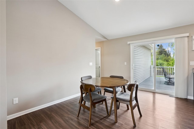dining area featuring lofted ceiling, baseboards, and dark wood finished floors
