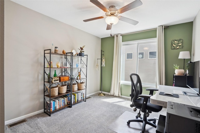 carpeted office with ceiling fan and baseboards