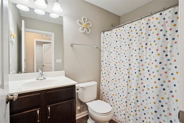 bathroom with vanity, toilet, and curtained shower