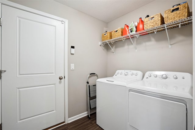 clothes washing area with separate washer and dryer, dark wood finished floors, and baseboards