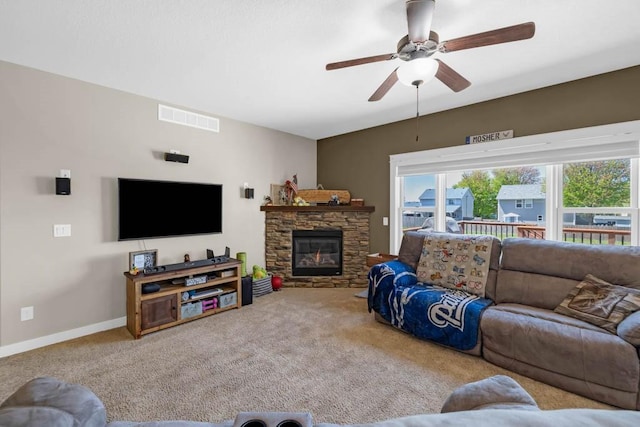 312 Evergreen Dr NW, Bondurant, IA 50035 - living area featuring a ceiling fan, carpet flooring, baseboards, and a stone fireplace