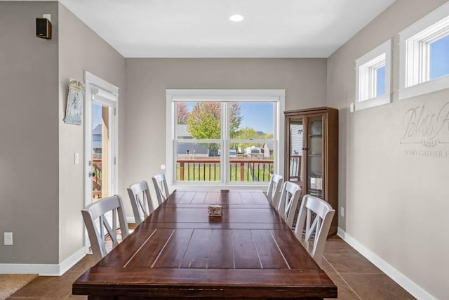 312 Evergreen Dr NW, Bondurant, IA 50035 - unfurnished dining area with dark tile patterned floors and baseboards