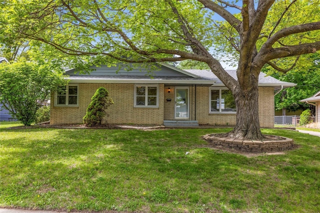 ranch-style house with a front yard and brick siding