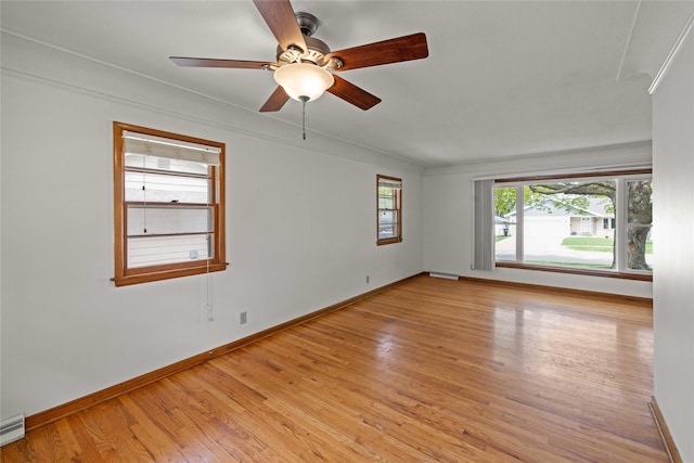 empty room with light wood-type flooring, baseboards, a baseboard heating unit, and a ceiling fan