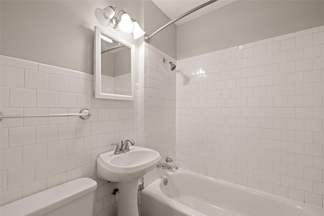 bathroom featuring toilet, bathtub / shower combination, and tile walls