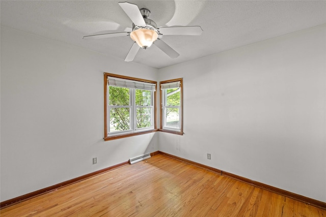 unfurnished room featuring light wood-type flooring, baseboards, a baseboard heating unit, and a ceiling fan