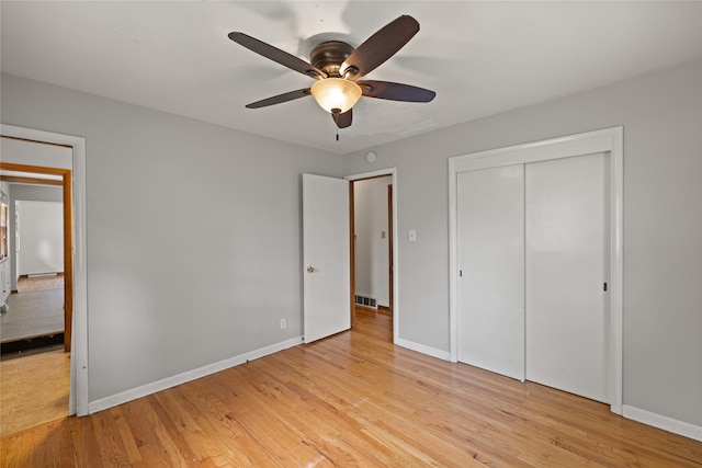 unfurnished bedroom with light wood-style floors, baseboards, a closet, and ceiling fan