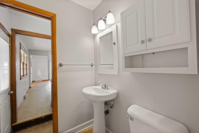 bathroom with toilet and baseboards
