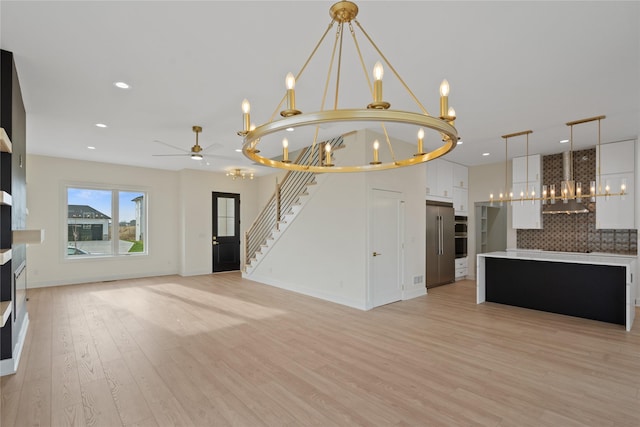 3943 NW 181st St, Clive, IA 50325 - unfurnished living room featuring a chandelier, light wood-style floors, recessed lighting, stairs, and ceiling fan