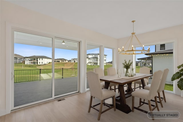 3943 NW 181st St, Clive, IA 50325 - dining space with a chandelier, light wood-type flooring, and a residential view