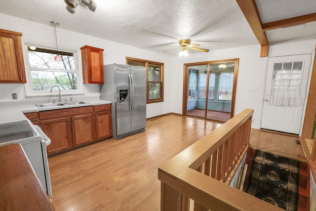 2226 Idaho Dr, Pella, IA 50219 - kitchen with stainless steel fridge, a sink, a ceiling fan, range, and light wood-style floors