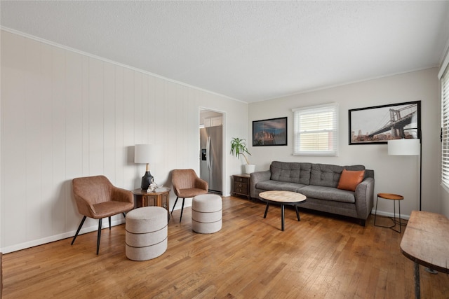 2012 61st St, Des Moines, IA 50322 - living room with wood finished floors, crown molding, baseboards, and a textured ceiling