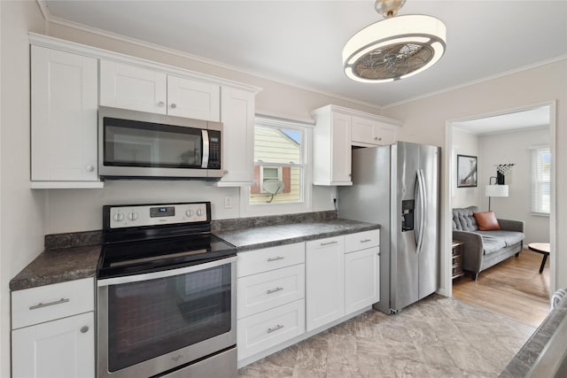 2012 61st St, Des Moines, IA 50322 - kitchen with appliances with stainless steel finishes, dark countertops, crown molding, and white cabinets