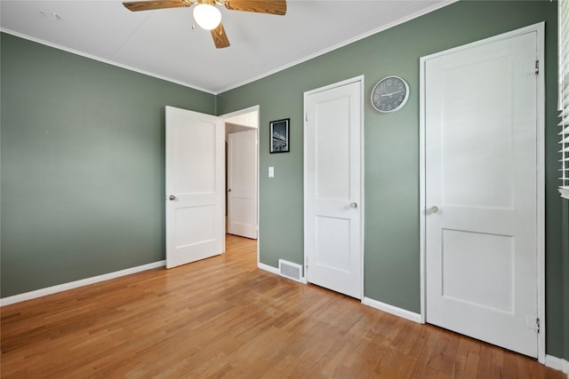 2012 61st St, Des Moines, IA 50322 - unfurnished bedroom featuring ornamental molding, baseboards, wood finished floors, and ceiling fan